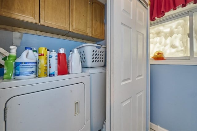 laundry area featuring baseboards, independent washer and dryer, and cabinet space