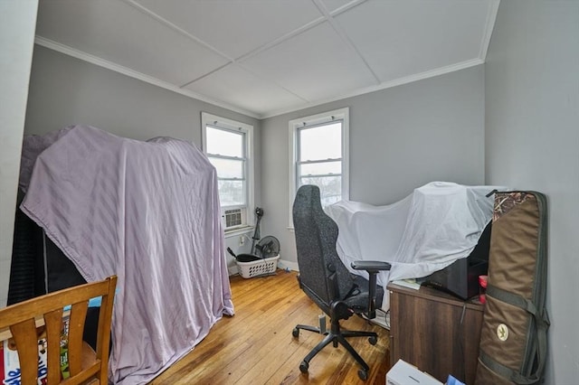 bedroom with wood-type flooring, crown molding, and baseboards