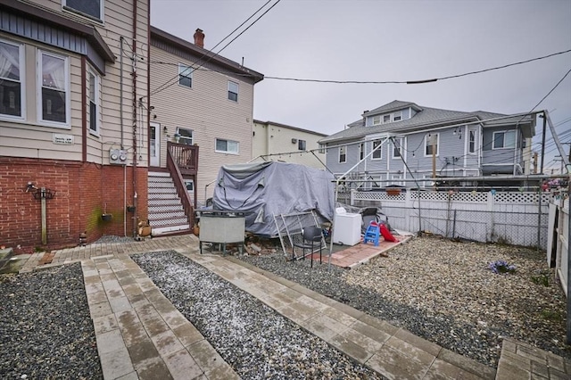 rear view of house featuring fence, a patio area, and stairway