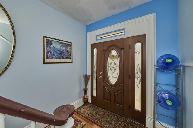 entrance foyer with baseboards and a textured ceiling