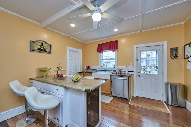 kitchen featuring crown molding, a sink, hardwood / wood-style flooring, dishwasher, and ceiling fan