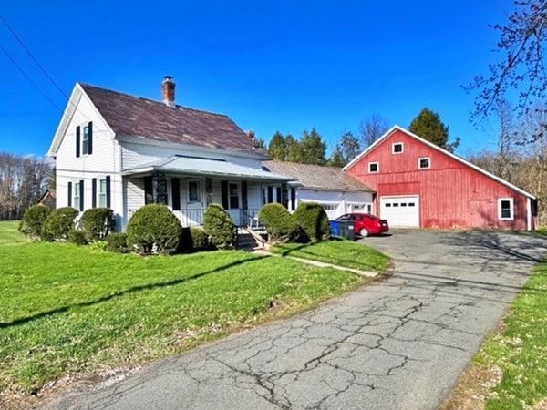 view of front of house with a front lawn, a garage, and a porch