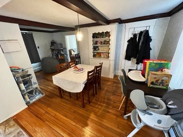 dining room with dark hardwood / wood-style floors and beam ceiling