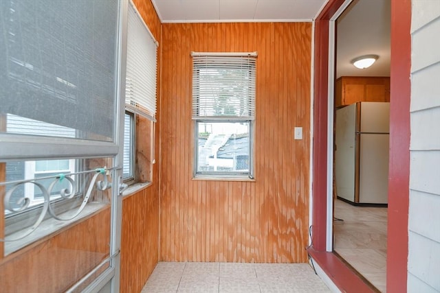 interior space with light tile patterned floors and wooden walls