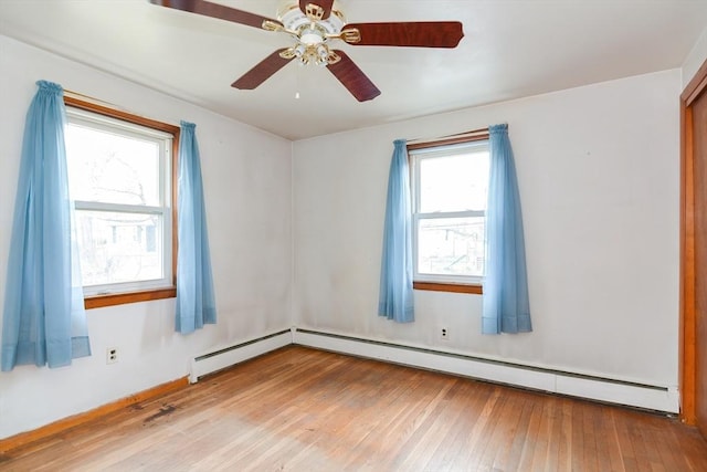 spare room featuring a wealth of natural light, ceiling fan, and light hardwood / wood-style floors