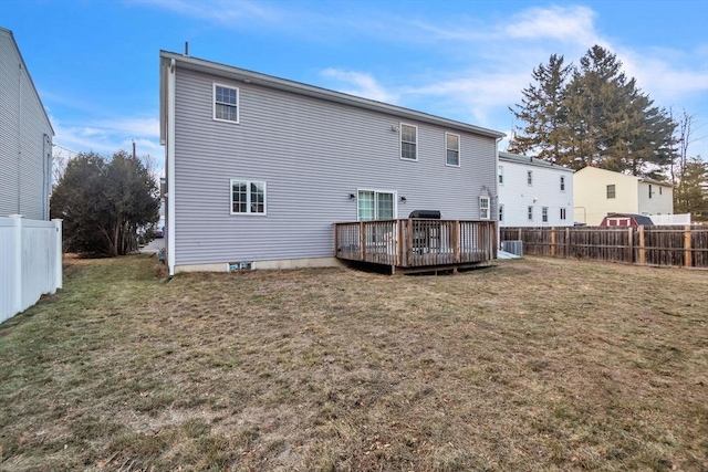 back of property featuring a deck and a yard