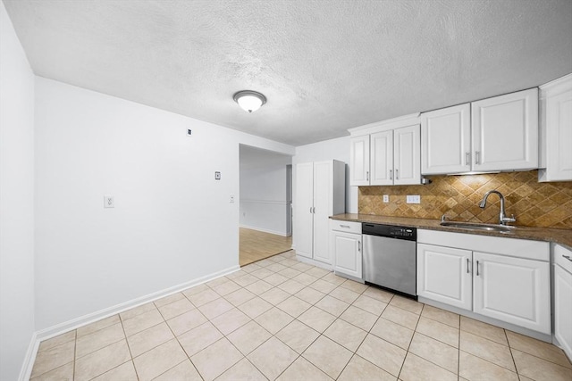 118 Parker St Unit 16, Acton, MA 01720 - kitchen featuring stainless steel dishwasher, a sink, backsplash, white cabinets, and a textured ceiling