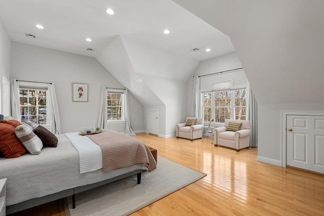 bedroom with light wood-style floors, multiple windows, visible vents, and vaulted ceiling