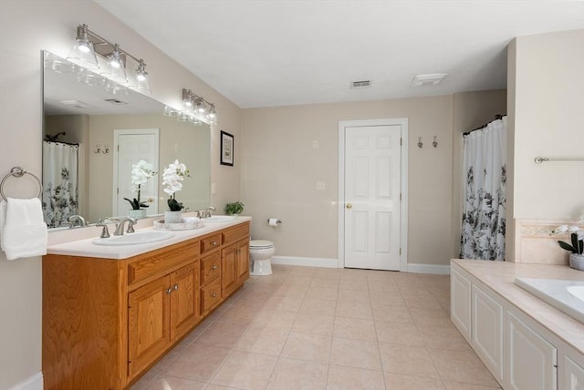 bathroom featuring a sink, visible vents, baseboards, tile patterned floors, and double vanity