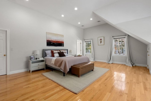 bedroom with lofted ceiling, light wood finished floors, baseboards, and recessed lighting