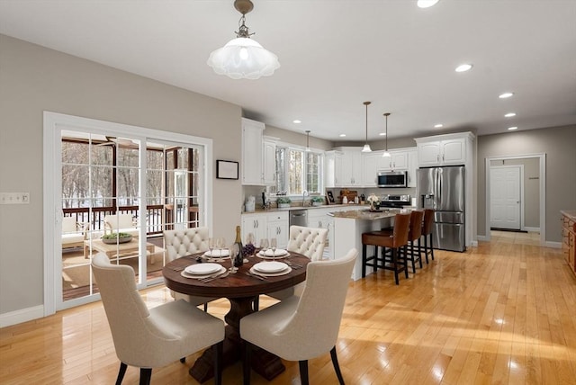 dining space with baseboards, recessed lighting, and light wood-style floors