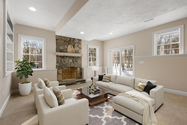 carpeted living area featuring a fireplace, recessed lighting, visible vents, a textured ceiling, and baseboards