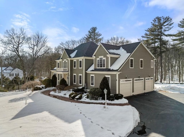 view of front of home with a garage, a balcony, and aphalt driveway