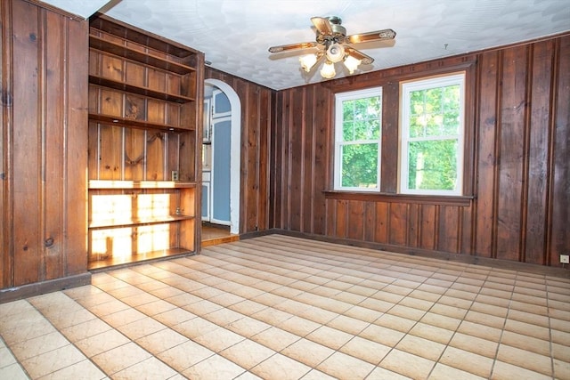 42 Giasson St, Hudson, MA 01749 - empty room with arched walkways, a ceiling fan, wood walls, and baseboards