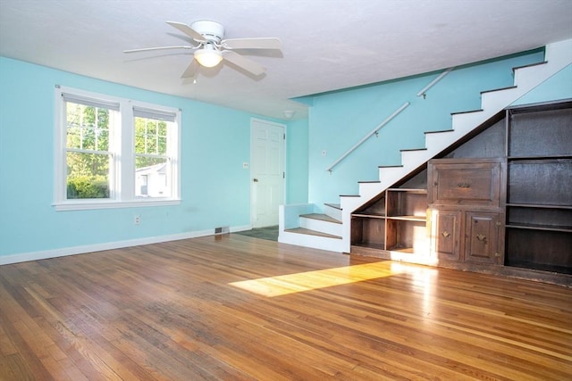 42 Giasson St, Hudson, MA 01749 - unfurnished living room featuring wood-type flooring, stairs, a ceiling fan, and baseboards