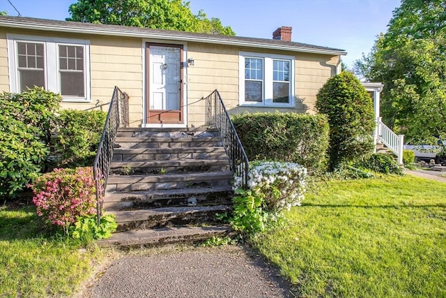 42 Giasson St, Hudson, MA 01749 - view of exterior entry with a chimney and a lawn