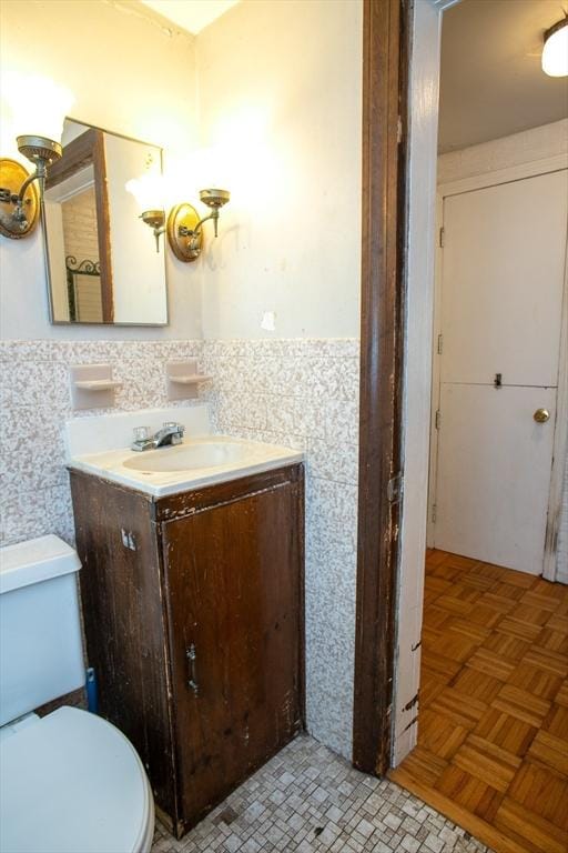 42 Giasson St, Hudson, MA 01749 - bathroom featuring toilet, vanity, wainscoting, and tile walls
