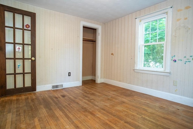 42 Giasson St, Hudson, MA 01749 - unfurnished bedroom with hardwood / wood-style flooring, wallpapered walls, baseboards, and a closet