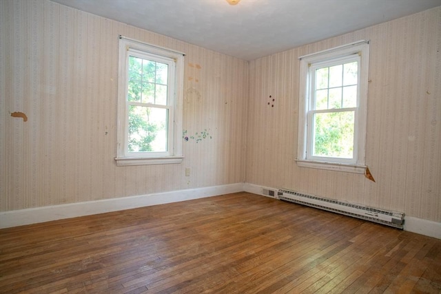 42 Giasson St, Hudson, MA 01749 - empty room featuring baseboard heating, hardwood / wood-style floors, healthy amount of natural light, and baseboards