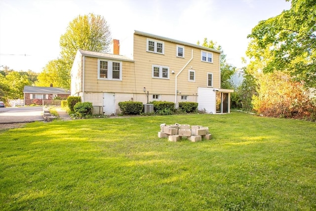 42 Giasson St, Hudson, MA 01749 - back of house with a yard, a chimney, and central air condition unit