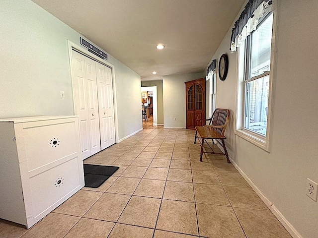 corridor with recessed lighting, baseboards, and light tile patterned floors