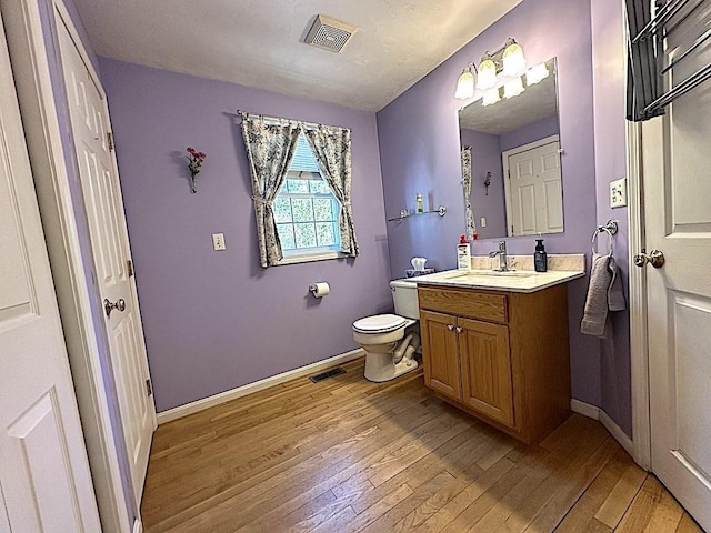 bathroom featuring toilet, visible vents, and hardwood / wood-style flooring