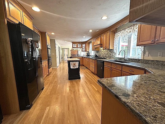 kitchen featuring recessed lighting, plenty of natural light, a sink, and black appliances