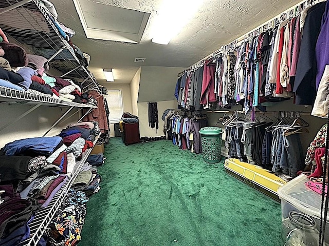 spacious closet featuring carpet floors, attic access, and visible vents