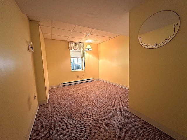 below grade area with baseboards, a baseboard heating unit, a drop ceiling, and carpet floors