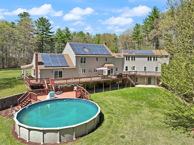 view of pool with stairway, a lawn, a fenced in pool, and a wooden deck