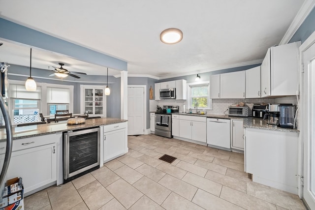 kitchen with white cabinets, wine cooler, appliances with stainless steel finishes, and sink