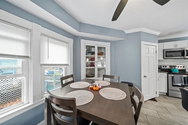 tiled dining area featuring ceiling fan and ornamental molding