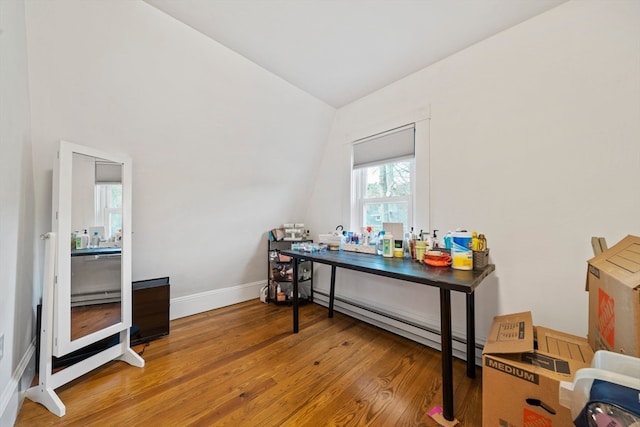 home office featuring baseboard heating, wood-type flooring, and vaulted ceiling