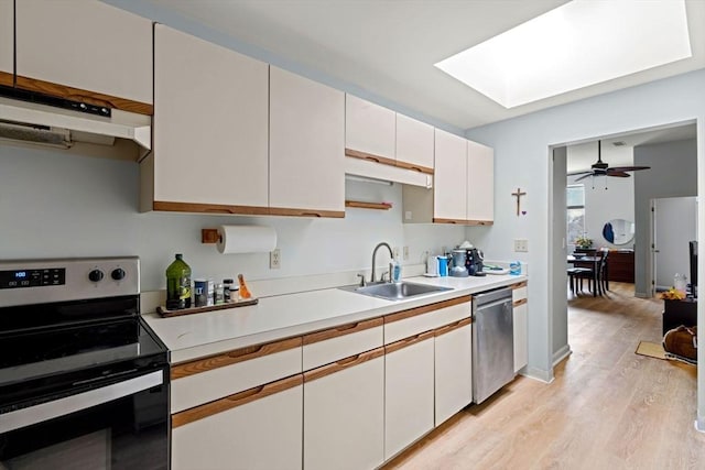 kitchen featuring light countertops, a sink, white cabinetry, under cabinet range hood, and stainless steel appliances
