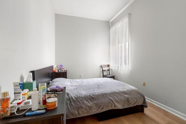 bedroom with baseboards and wood finished floors