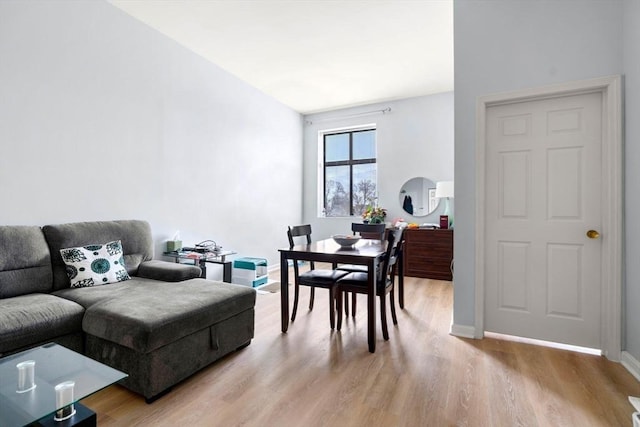 living area featuring baseboards and light wood-type flooring