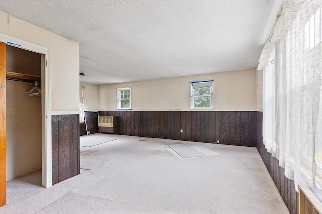 34 Worcester St, Grafton, MA 01519 - unfurnished bedroom with a wainscoted wall, multiple windows, carpet floors, wooden walls, and a textured ceiling