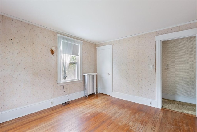 34 Worcester St, Grafton, MA 01519 - spare room with radiator, wood finished floors, wallpapered walls, and ornamental molding