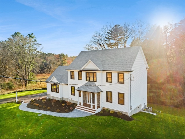 view of front of home with central AC and a front lawn