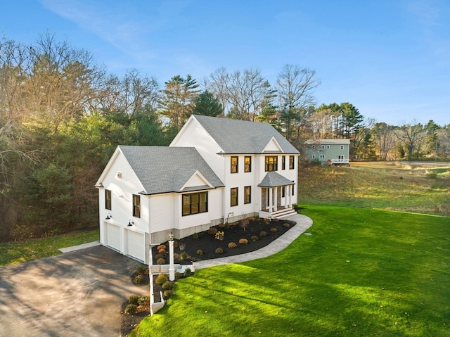 view of front of house featuring a porch, a garage, and a front lawn