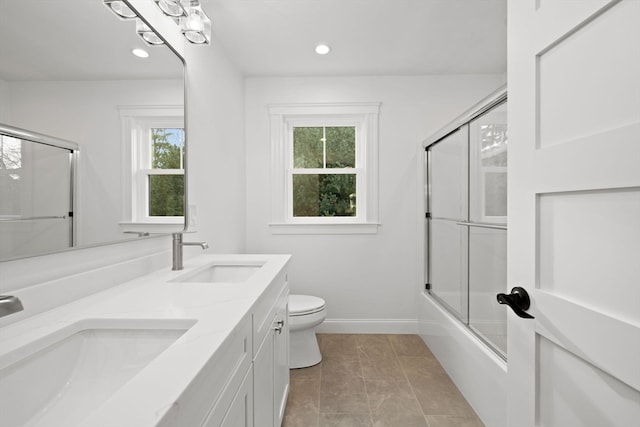 full bathroom with vanity, enclosed tub / shower combo, and toilet