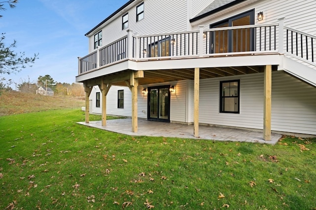 back of property featuring a patio area, a yard, and a wooden deck