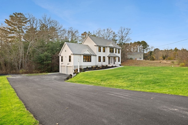 view of front of property featuring a front lawn and a garage