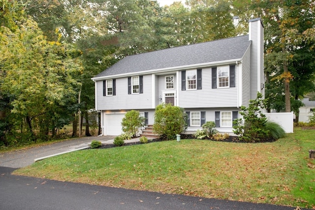 bi-level home with a front lawn and a garage