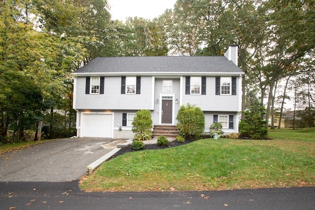 bi-level home with a garage and a front lawn