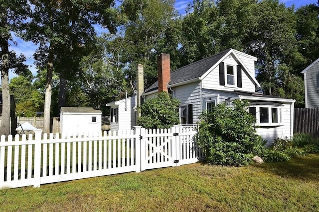 216 Waltham St, Hanson, MA 02341 - view of front of house featuring a chimney, an outdoor structure, and a shed