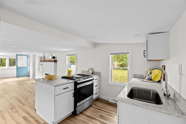 216 Waltham St, Hanson, MA 02341 - kitchen with stainless steel range with gas cooktop, a sink, light wood-style floors, baseboards, and light stone countertops