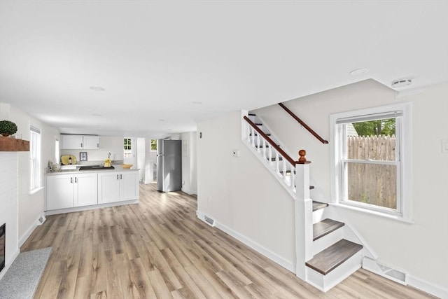 216 Waltham St, Hanson, MA 02341 - unfurnished living room featuring baseboards, stairway, and light wood finished floors