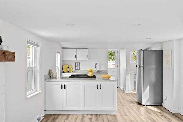 216 Waltham St, Hanson, MA 02341 - kitchen featuring stainless steel appliances, light wood finished floors, baseboards, white cabinets, and a peninsula