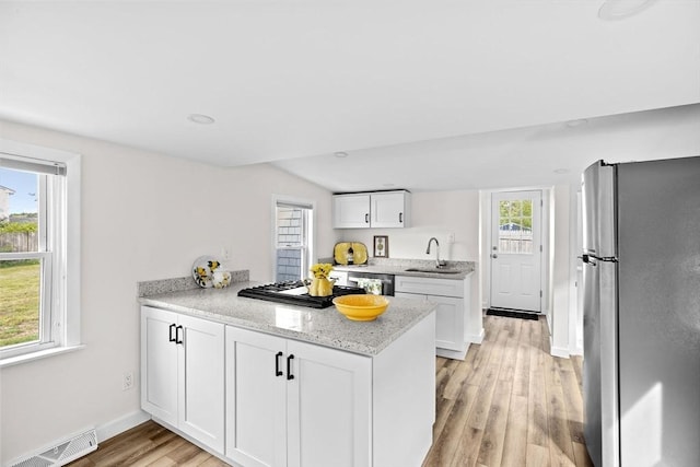 216 Waltham St, Hanson, MA 02341 - kitchen with appliances with stainless steel finishes, a sink, a peninsula, white cabinetry, and light wood-type flooring